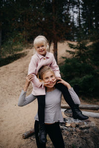 Portrait of girl carrying sister on shoulder