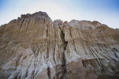 Low angle view of rock formations against sky