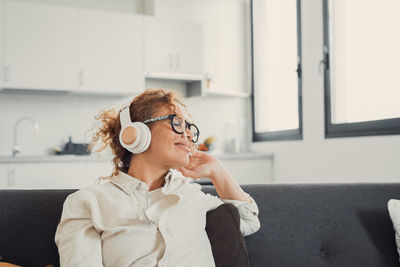 Young woman using mobile phone while sitting at home