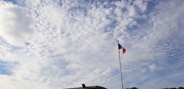 Low angle view of flag flags against sky