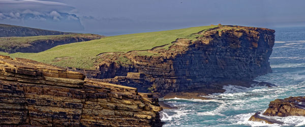 Scenic view of sea and mountains against sky