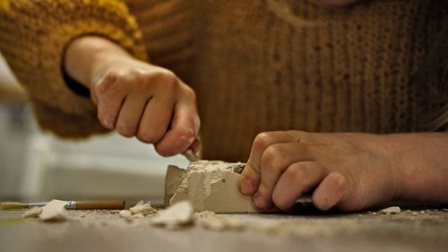 Midsection of woman carving on table