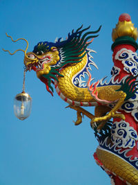 Low angle view of statue dragon against sky