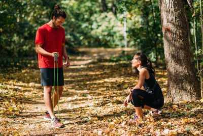 Young couple exercising with elastic resistance band outdoors in the park