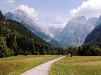 Scenic view of road by mountains against sky