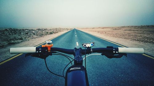 Bicycle on road in city against clear sky