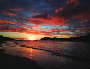 Scenic view of sea against dramatic sky during sunset