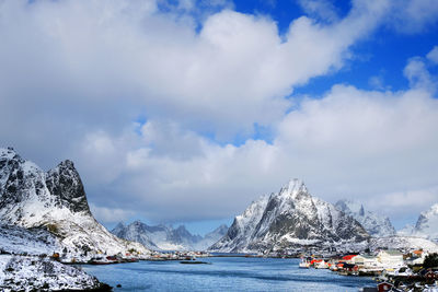 Scenic view of snowcapped mountains by sea against sky