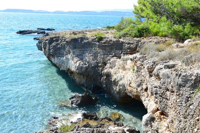 Scenic view of rocks in sea against sky