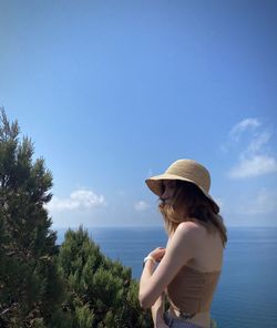 Rear view of woman looking at sea against sky