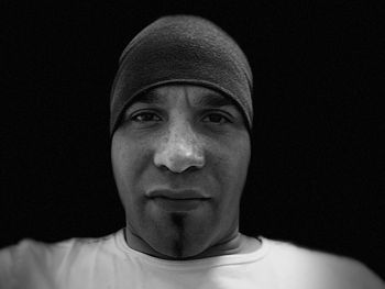 Close-up portrait of young man against black background