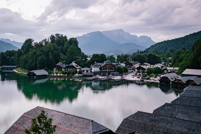 Houses by lake and buildings against sky