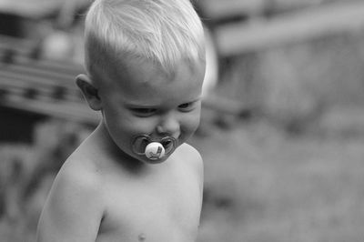 Cute boy sucking pacifier outdoors