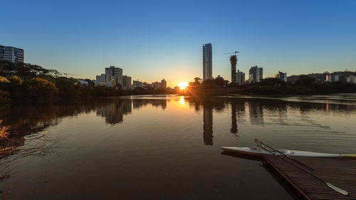 Reflection of buildings in city at sunset