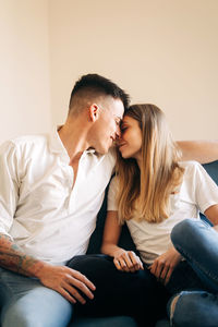 Young couple sitting on sofa at home