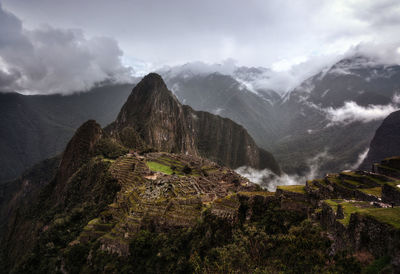 Scenic view of mountain range against cloudy sky