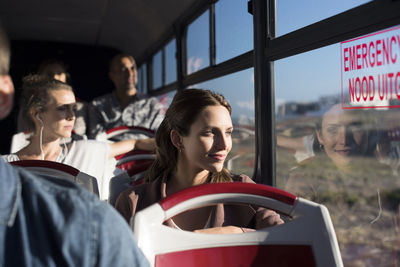 Passengers looking through window while traveling in tour bus