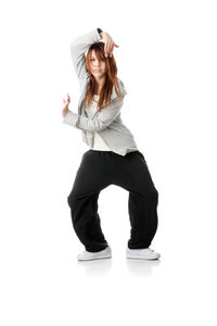 Portrait of young woman standing against white background