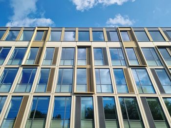 Low angle view of glass building against sky