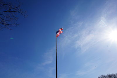 Low angle view of american flag against blue sky