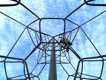 Young girl on top of playground rope structure 