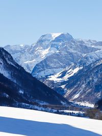 Scenic view of snowcapped mountains against clear blue sky