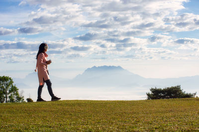 A young woman looking at the mountains and the sea of fog. huai nam dang, chiang mai, thailand 