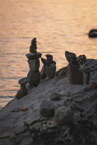 Stack of stones on shore during sunset