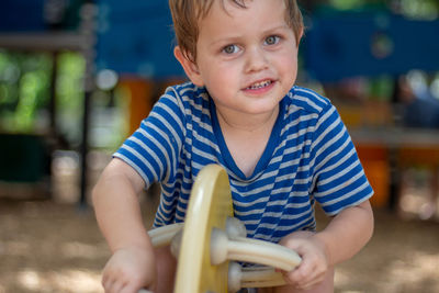 Portrait of cute boy playing on seesaw