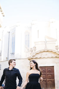 Couple walking against historic building