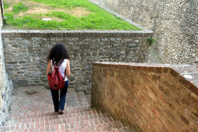 Full length of woman standing against wall
