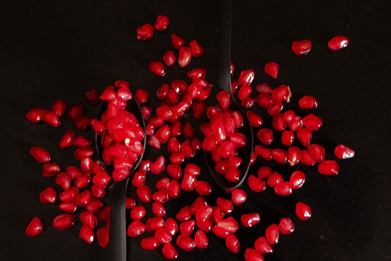 HIGH ANGLE VIEW OF RED BERRIES ON BLACK BACKGROUND