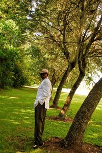 Rear view of man standing by tree trunk