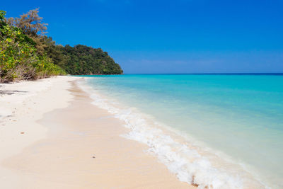 Scenic view of beach against blue sky