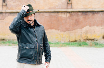 Portrait of man wearing hat standing on street