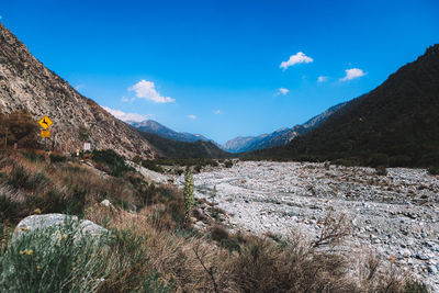 Scenic view of mountains against blue sky