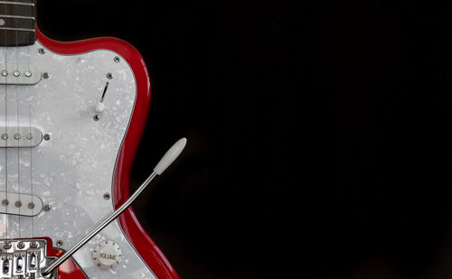 Close-up of guitar against black background