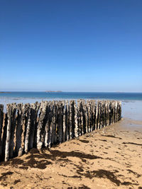 Scenic view of beach against clear blue sky