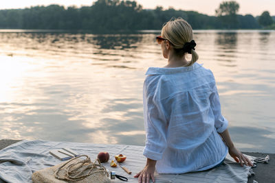 Young woman is resting in the evening by the lake.