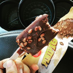 Close-up of hand holding ice cream cone in car