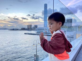 Portrait of boy looking at sea against sky