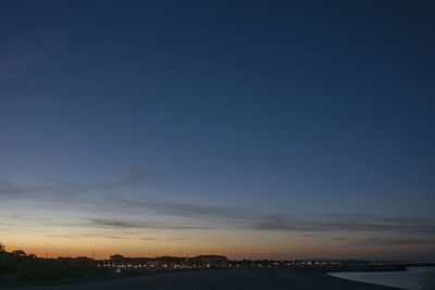 Scenic view of sea by buildings against sky during sunset