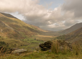 Scenic view of field and mountains against sky