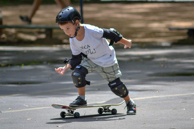 Full length of boy riding skateboard