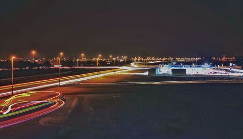 Light trails on road against sky at night