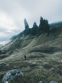 Rear view of hiker on mountain against sky