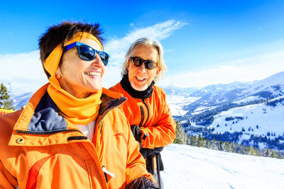 Portrait of happy friends standing on snow covered landscape