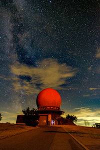 Illuminated built structure against sky at night