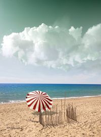 Umbrella on beach against sky