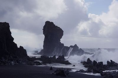 Panoramic view of rocks on beach against sky